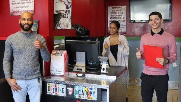 Three trucking students smiling with thumbs up.